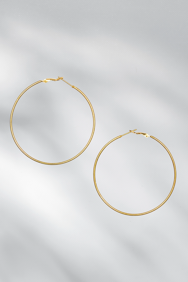 Gold hoop earrings on a light gray background